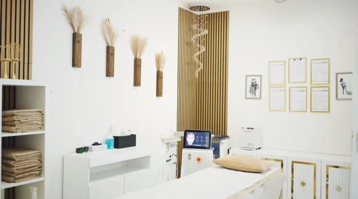 Heller Behandlungsraum von Kosmetik Korallen in München-Hadern mit Behandlungsliege, Kosmetikgeräten und Holzlamellen an der Wand