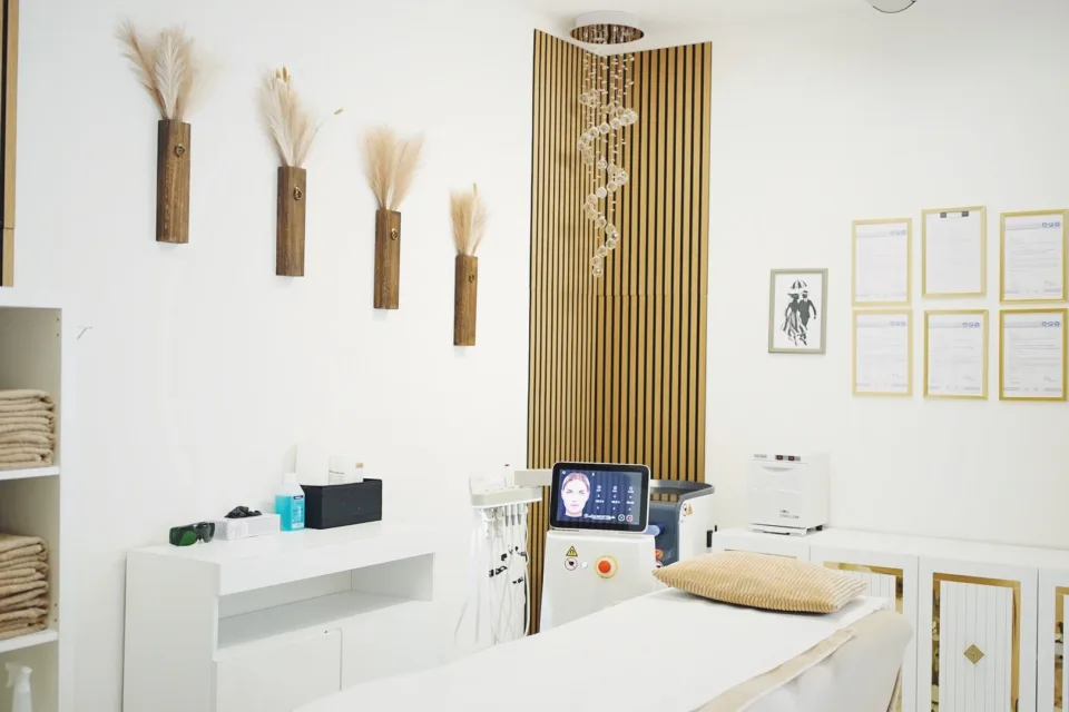 Heller Behandlungsraum von Kosmetik Korallen in München-Hadern mit Behandlungsliege, Kosmetikgeräten und Holzlamellen an der Wand