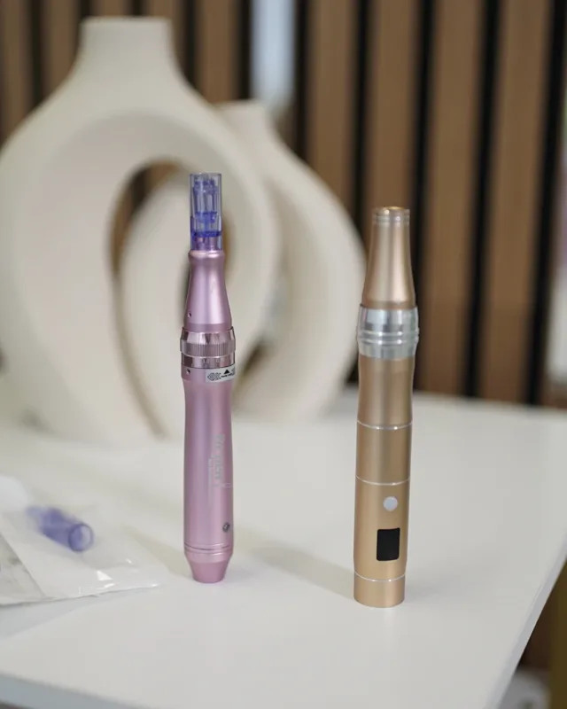 Zwei Microneedling-Geräte mit Nadelaufsätzen auf einem Tisch